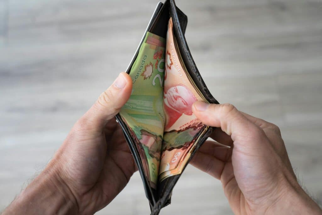 Winner of the $100 Weekly Cash Calendar Prize Draw - November 21 - 2025 4 Image of hands holding an open wallet with Canadian banknotes visible, representing personal finance.